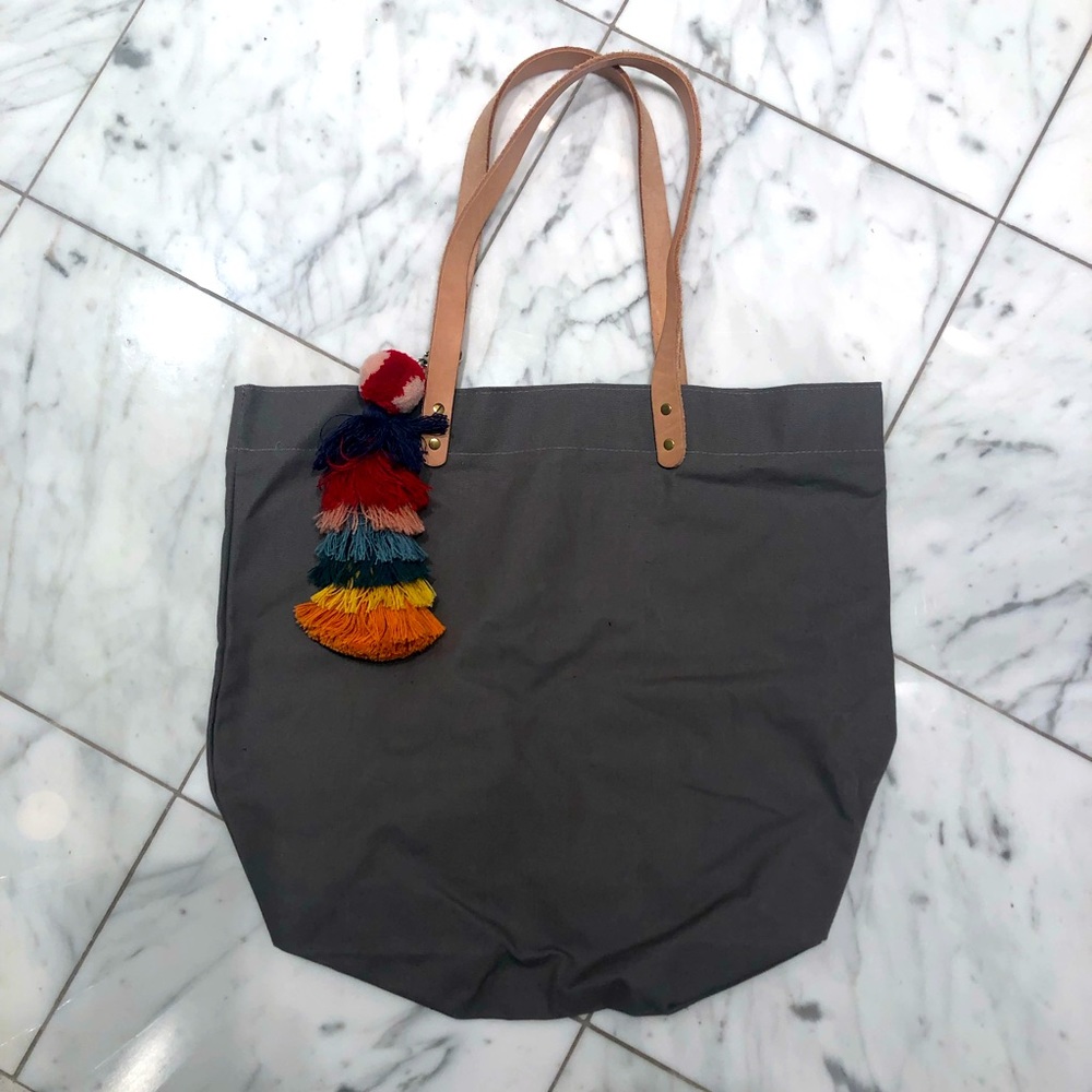 Grey canvas tote with raw leather straps and charm